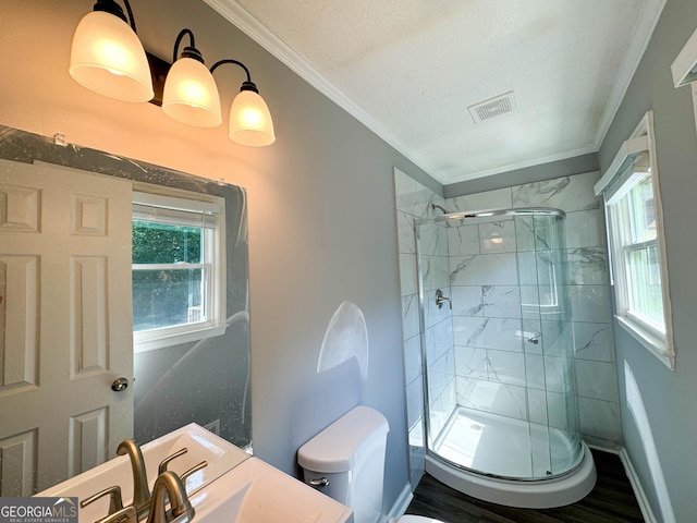 bathroom featuring wood-type flooring, toilet, a shower with door, and ornamental molding