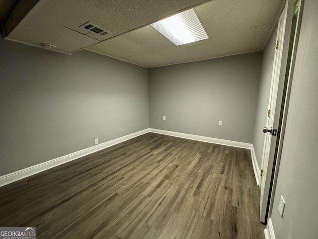 spare room with hardwood / wood-style flooring and a drop ceiling