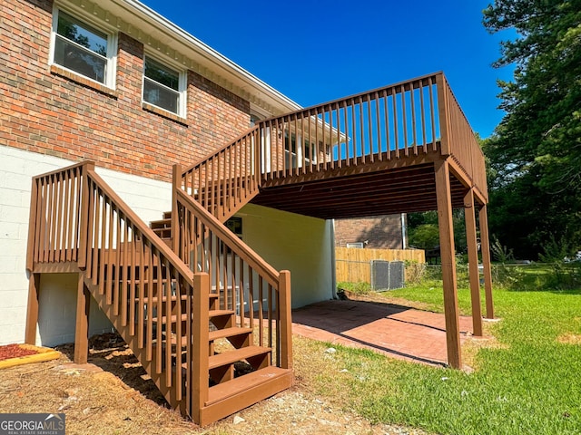 wooden deck featuring a patio and a lawn