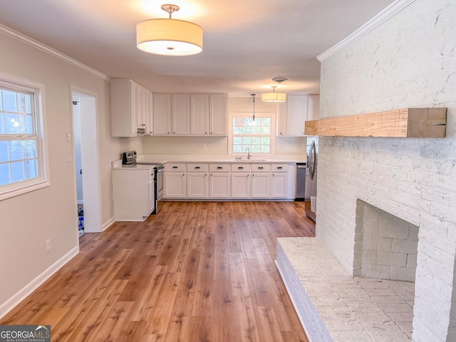 kitchen featuring pendant lighting, sink, crown molding, stainless steel electric stove, and white cabinets