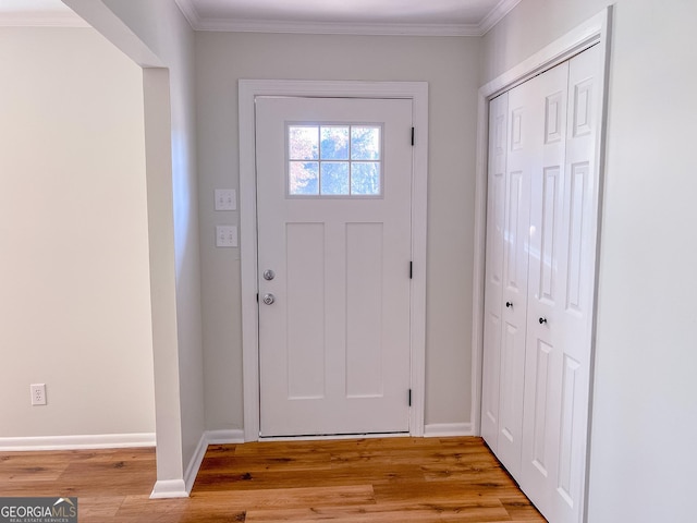 foyer entrance with light wood-type flooring and ornamental molding