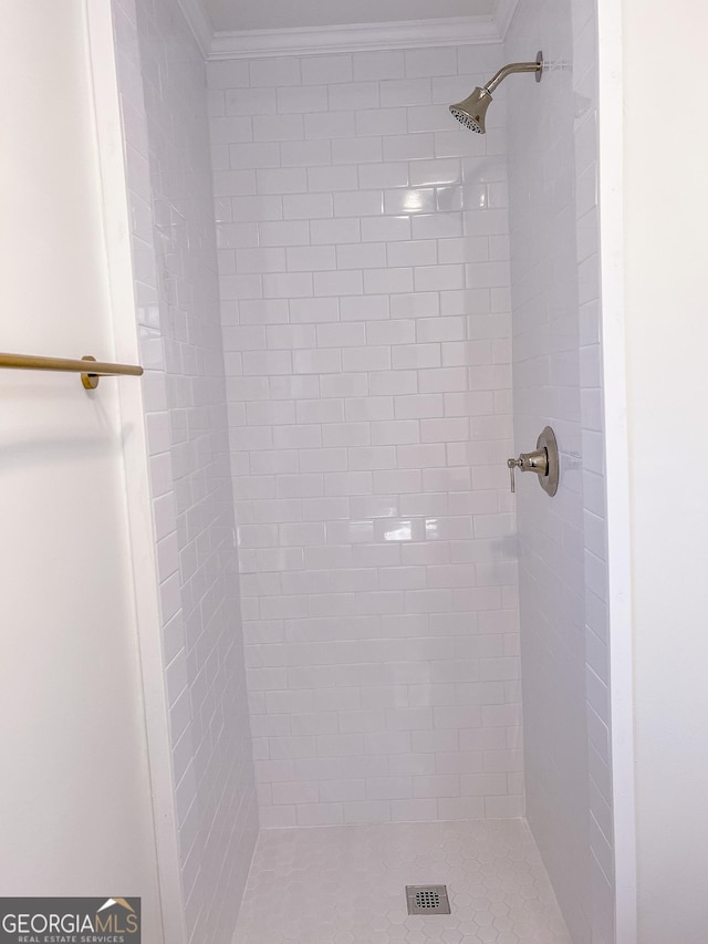 bathroom with crown molding and tiled shower