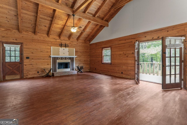 unfurnished living room featuring hardwood / wood-style flooring, a brick fireplace, wood ceiling, and wood walls