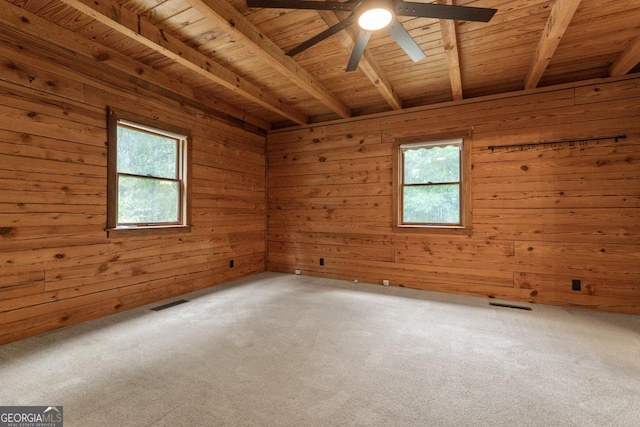 spare room featuring wooden ceiling, a healthy amount of sunlight, and carpet