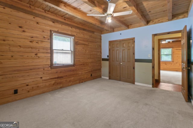 unfurnished bedroom featuring wood ceiling, wooden walls, and beamed ceiling