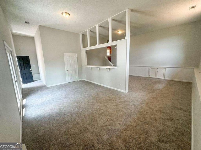 carpeted spare room featuring a textured ceiling