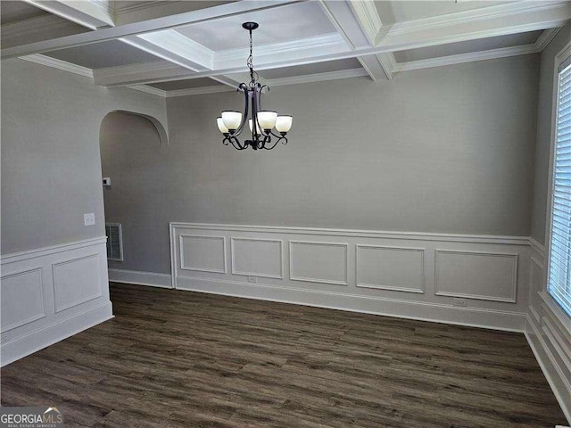 unfurnished dining area with beamed ceiling, ornamental molding, coffered ceiling, and an inviting chandelier