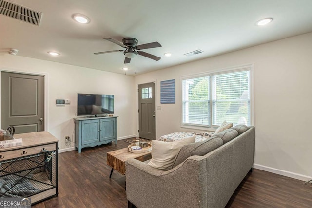 living room featuring ceiling fan and dark hardwood / wood-style floors