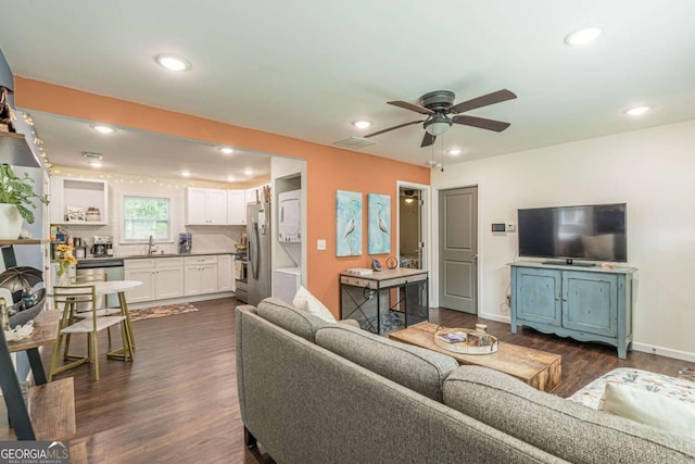 living room with dark hardwood / wood-style flooring, ceiling fan, and sink