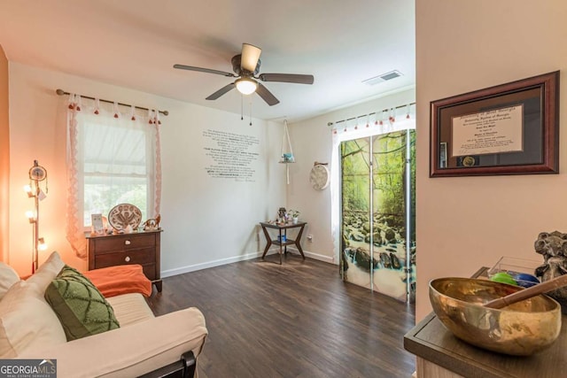 living area with ceiling fan and dark wood-type flooring