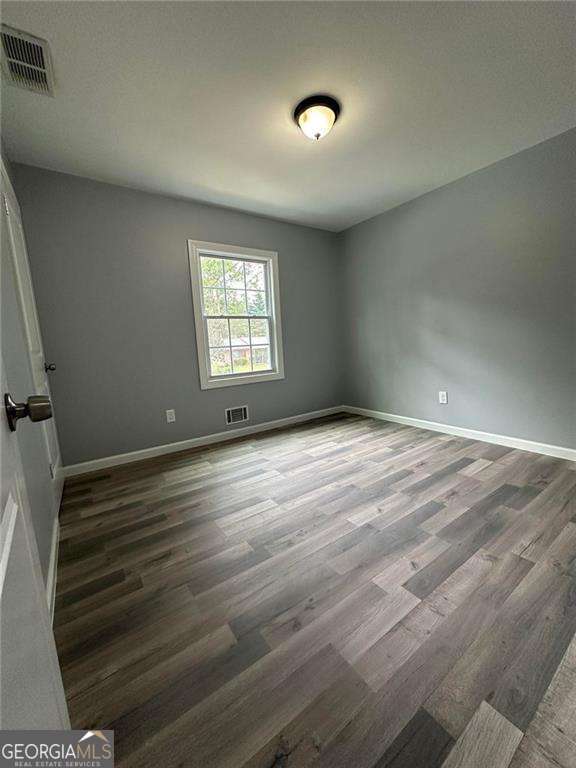 unfurnished room featuring dark hardwood / wood-style flooring