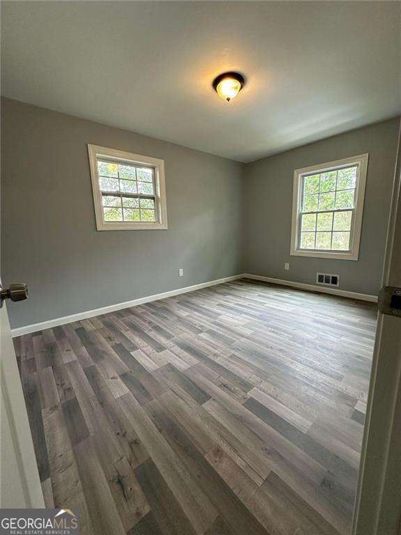 unfurnished room featuring dark hardwood / wood-style floors