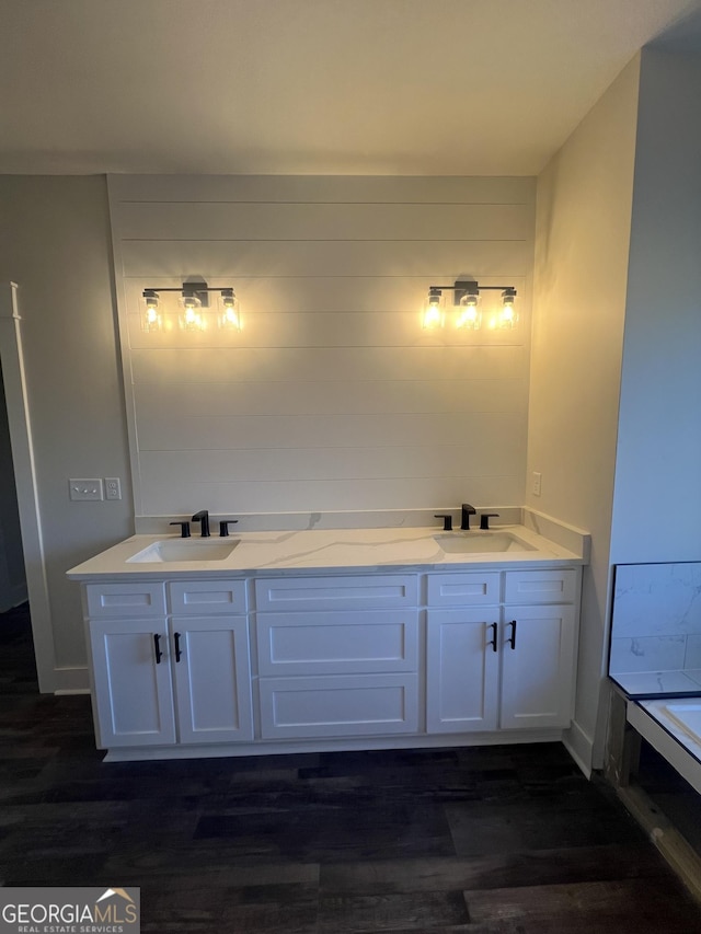 bathroom featuring hardwood / wood-style floors, vanity, and a washtub