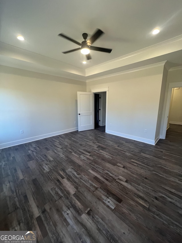 spare room featuring ceiling fan, dark hardwood / wood-style flooring, crown molding, and a tray ceiling