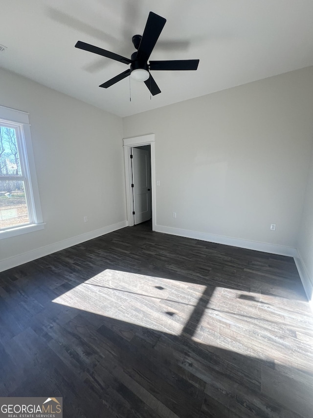 empty room featuring ceiling fan and dark hardwood / wood-style floors