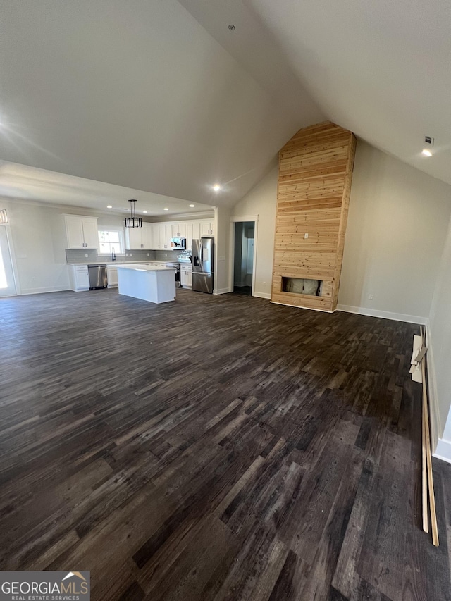 unfurnished living room featuring dark hardwood / wood-style floors, lofted ceiling, and a fireplace