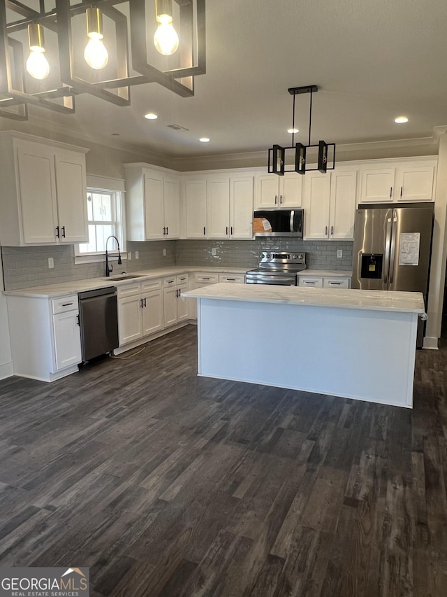 kitchen with white cabinets, sink, hanging light fixtures, and appliances with stainless steel finishes