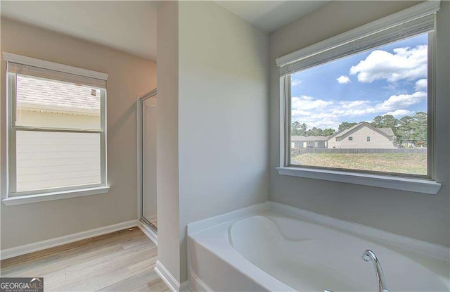 bathroom featuring separate shower and tub and plenty of natural light