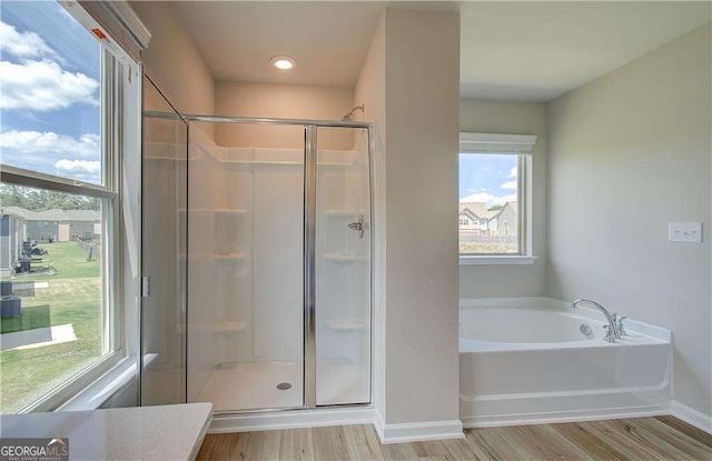 bathroom featuring hardwood / wood-style floors and plus walk in shower