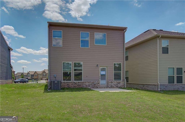 rear view of house with a lawn, central AC, and a patio