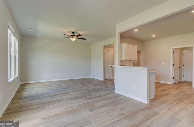 unfurnished living room featuring ceiling fan and light hardwood / wood-style flooring