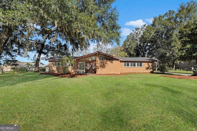 rear view of house featuring a yard