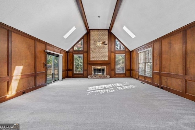 unfurnished living room featuring beamed ceiling, ceiling fan, a brick fireplace, high vaulted ceiling, and light colored carpet