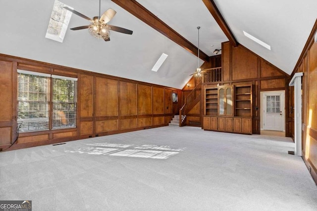 unfurnished living room featuring high vaulted ceiling, light carpet, ceiling fan, and beamed ceiling