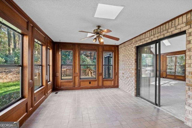 unfurnished sunroom featuring a skylight and ceiling fan