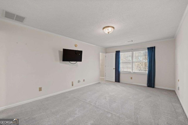 carpeted spare room with ornamental molding and a textured ceiling