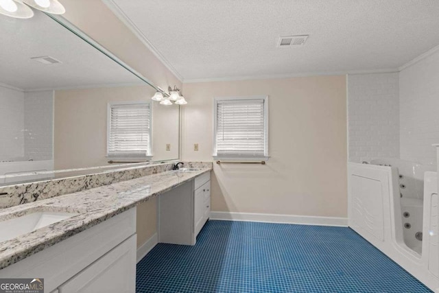 bathroom with a textured ceiling, a healthy amount of sunlight, a bathtub, and vanity