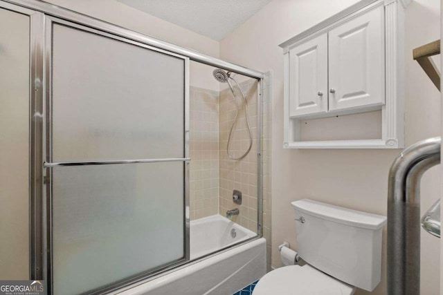 bathroom with toilet, bath / shower combo with glass door, and a textured ceiling