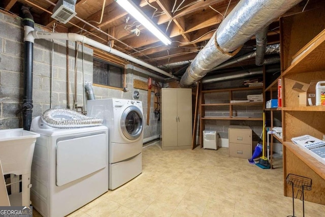 clothes washing area with washing machine and dryer