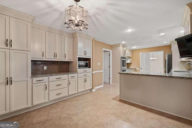 kitchen featuring a textured ceiling, hanging light fixtures, decorative backsplash, appliances with stainless steel finishes, and cream cabinetry