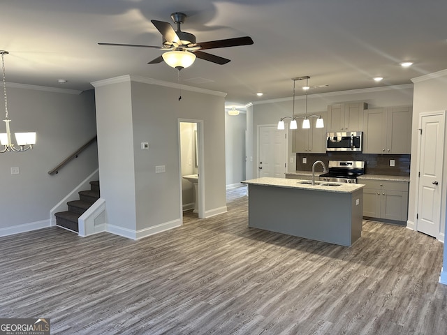 kitchen with gray cabinetry, a center island with sink, stainless steel appliances, and hanging light fixtures