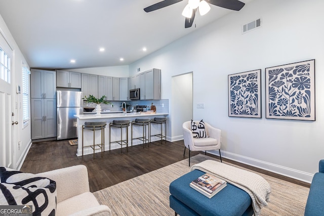 living room featuring recessed lighting, visible vents, baseboards, vaulted ceiling, and dark wood-style floors