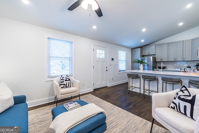 living room featuring lofted ceiling, baseboards, dark wood finished floors, and recessed lighting