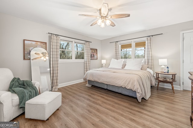 bedroom featuring multiple windows, ceiling fan, and light hardwood / wood-style flooring