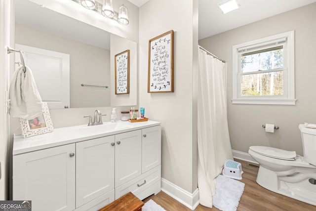 bathroom featuring walk in shower, vanity, wood-type flooring, and toilet