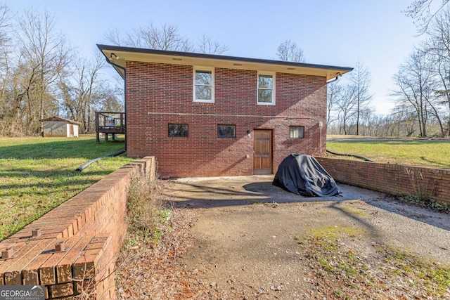 back of property with a deck and a yard