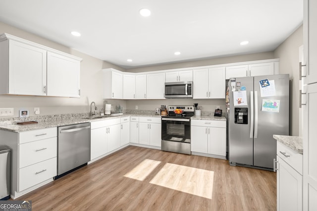 kitchen with white cabinetry, sink, and stainless steel appliances