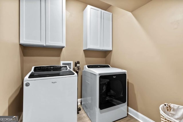 washroom with cabinets, independent washer and dryer, and light wood-type flooring