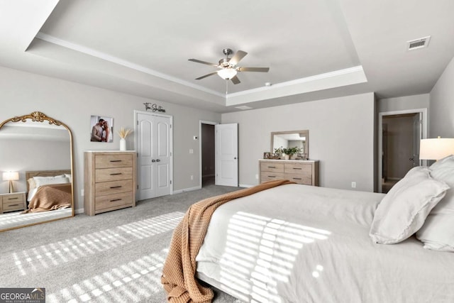 bedroom featuring carpet flooring, a tray ceiling, ceiling fan, and ornamental molding