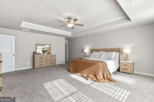 bedroom featuring ceiling fan, a raised ceiling, ornamental molding, and light carpet