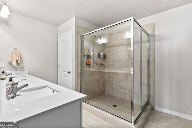 bathroom with tile patterned floors, vanity, and a shower with door