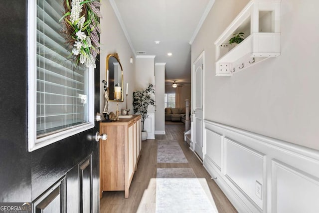 hall featuring ornamental molding and light hardwood / wood-style flooring