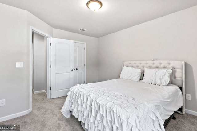 bedroom featuring a closet and light colored carpet