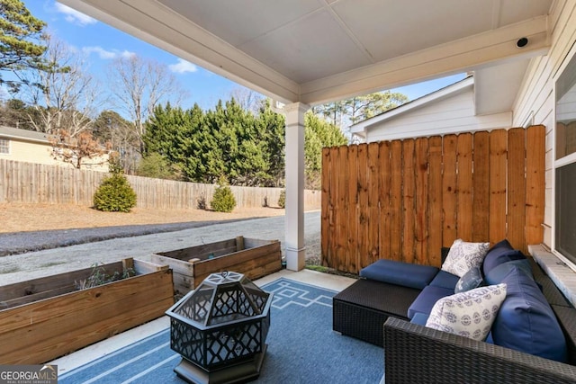 view of patio with an outdoor living space with a fire pit