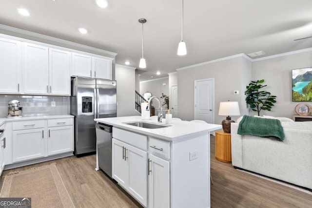 kitchen featuring white cabinetry, an island with sink, stainless steel appliances, and decorative light fixtures