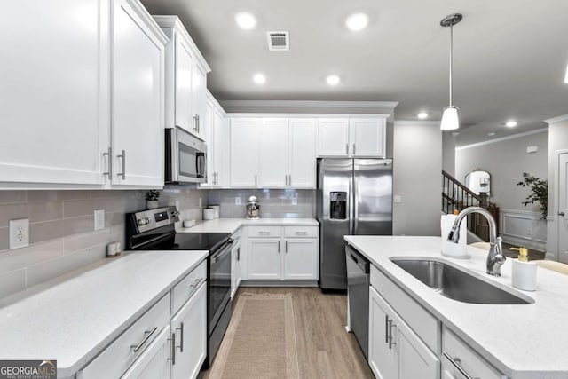 kitchen with white cabinetry, sink, decorative light fixtures, decorative backsplash, and appliances with stainless steel finishes